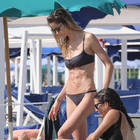 Elena Santarelli mamma al mare, semplice bikini nero e maxi tuta bohémien