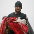 Terremoto in Turchia e Siria, un papà stringe il figlio morto avvolto in una coperta. L'immagine simbolo