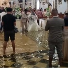 Matrimonio nella chiesa allagata: il tifone non ferma i due sposini, a nozze "passeggiando" nell'acqua VIDEO