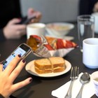 Guardare lo smartphone a tavola fa ingrassare, lo studio: «Il corpo assume più calorie»