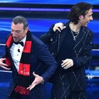 Sangiovanni mette una sciarpa del Milan all'interista Amadeus: lo scherzo sul palco di Sanremo