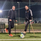 Simone Perrotta con Arturo Mariani in campo con le stampelle per il calcio inclusivo