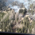 Fiamme tra gli alberi schiantati da "Vaia": brucia il bosco a Col Curiè