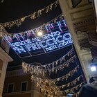 Roma, le luminarie in via del Corso con le frasi e i versi di romani celebri: da Gigi Proietti a Ennio Morricone